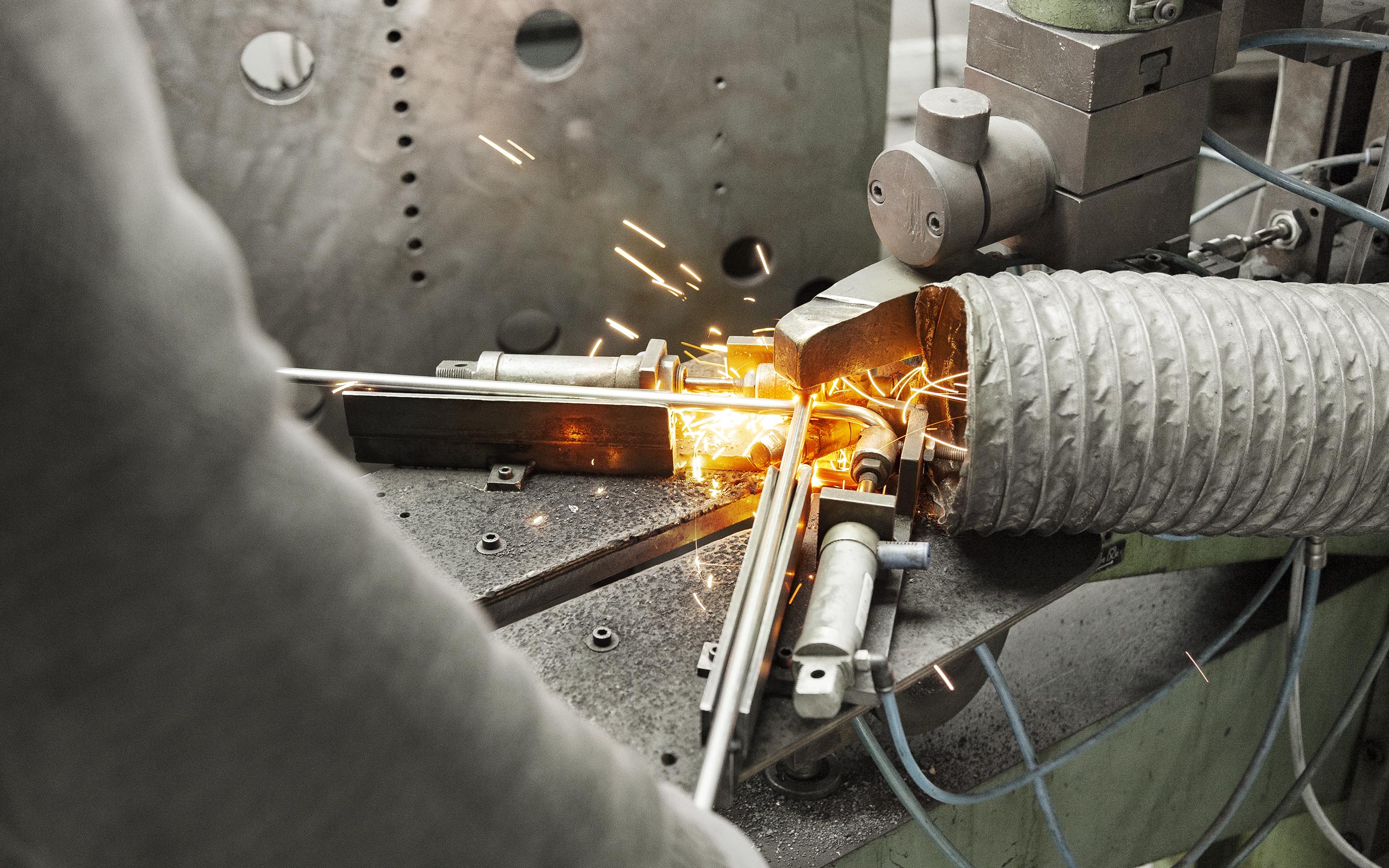 Mitarbeitender schweißt zwei Metalldrähte zusammen